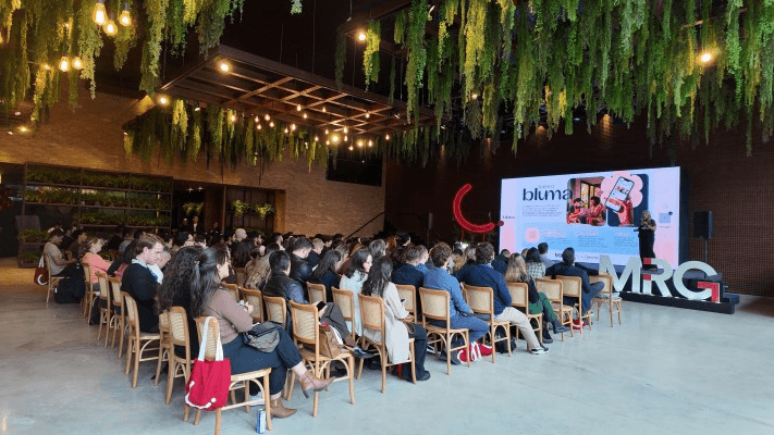 Plateia do evento MRG, com a apresentação no telão ao fundo. Foto: divulgação MRG.